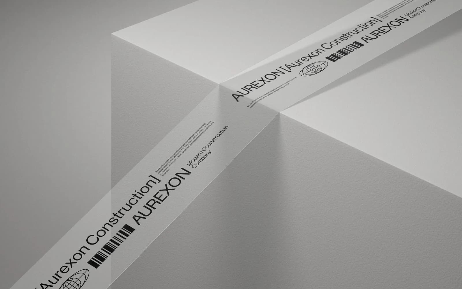 White packing tape printed with AUREXON [Aurexon Construction], Modern Construction Company, a globe icon and a barcode, wrapped around a white box.