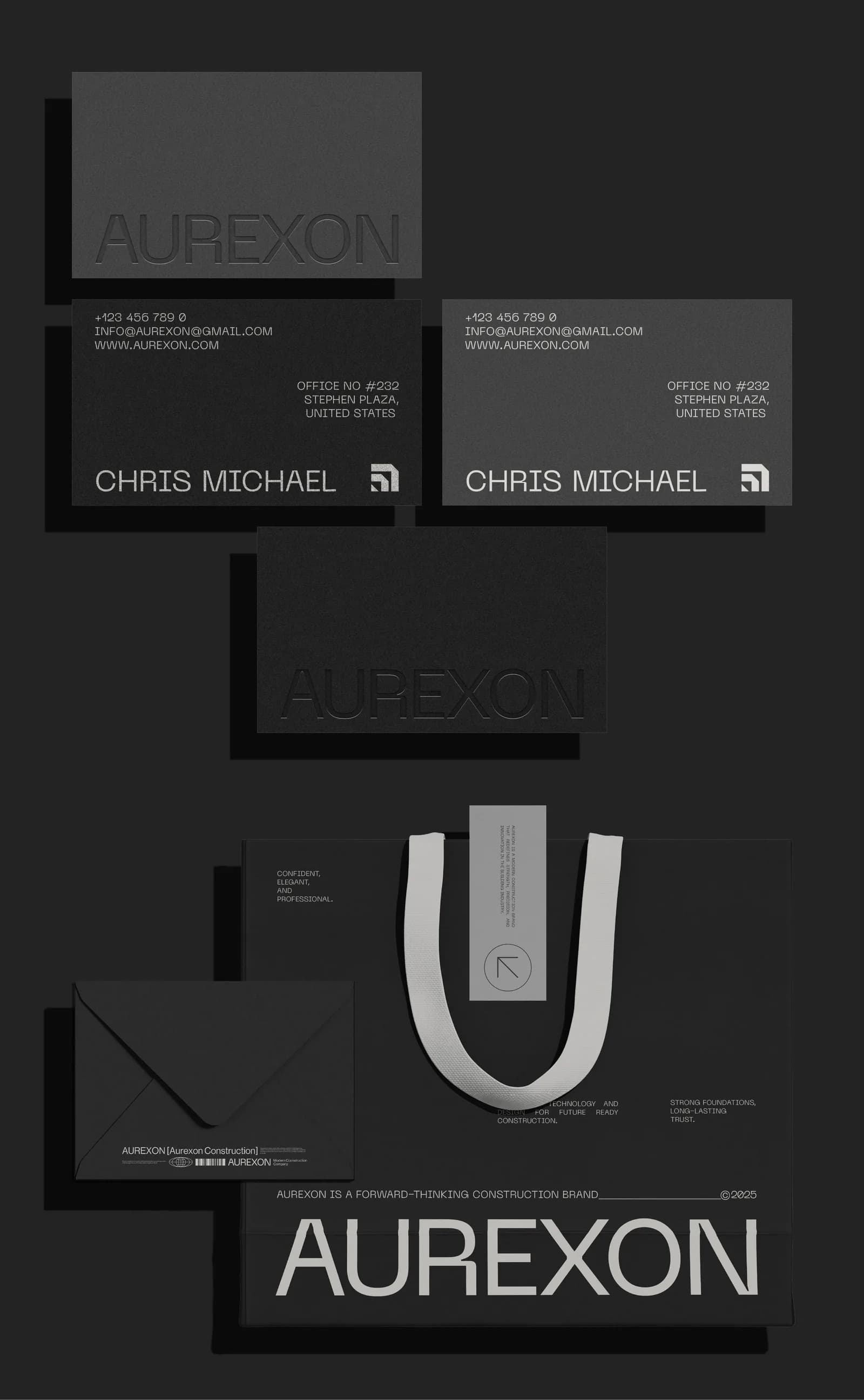 Aurexon stationery on a black background: a blind-embossed dark card, two business cards in black and grey for Chris Michael, a black envelope, and a black shopping bag with the wordmark in large white type and a grey swing tag